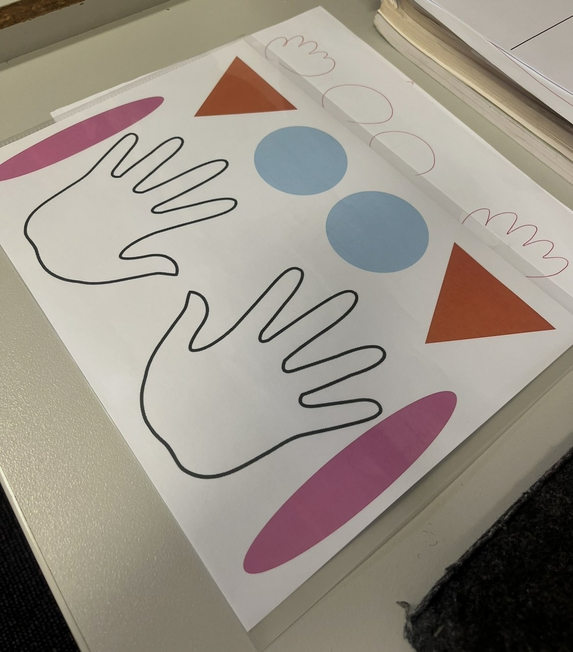 A laminated sheet of hand outlines and coloured shapes used for rhythm walking
